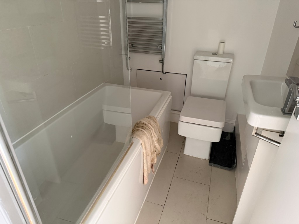 Lot: 196 - TWO-BEDROOM BALCONY FLAT IN CENTRAL LOCATION - White bathroom suite with WC and sink unit